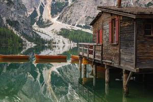 close up of iconic boathouse and boats with mount Seekofel mirroring in the clear calm water of  Pragser Wildsee Lago di Braies in Dolomites Unesco World Heritage photo
