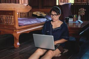 young woman working sitting on couch with laptop at home photo