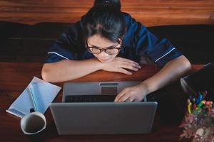 young woman working sitting on couch with laptop at home photo