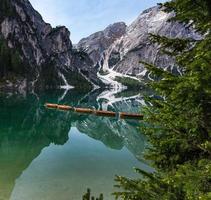 high angle view of boats with mount Seekofel mirroring in the clear calm water of  iconic Pragser Wildsee Lago di Braies in Dolomites photo