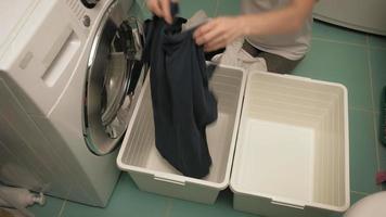 uma mulher separa a roupa antes de lavar