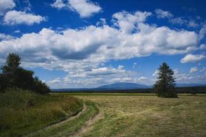 Autumn landscape with clouds and mown grass photo