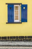 ventana azul con corazones y pared amarilla foto