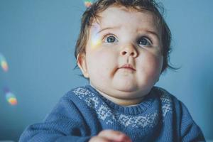 Little baby surrounded by rainbow lights photo