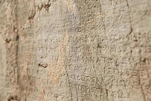 Escritura antigua en el sitio histórico de Delfos, Grecia foto