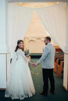 Young bride and groom on their wedding day in a church building photo