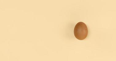 huevo marrón sobre fondo beige con espacio de copia