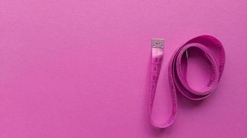 Pink centimeter on pink background Simple flat lay with pastel texture Fitness concept Stock photo