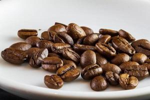 Macro de granos de café en una taza de café con leche