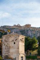 Tower of the Wind gods in Roman Agora and Acropolis in the background photo