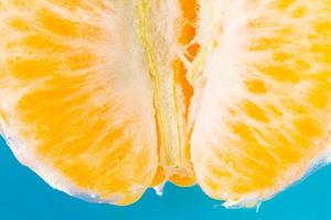 Sliced fresh Tangerine on blue background photo