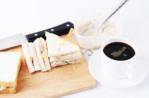 Deliciosos sándwiches de atún caseros con taza de café. foto