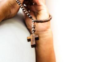 human pray to god with wood rosary photo