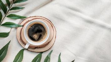 Top view of cup of coffee on a white tablecloth photo