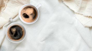 Top view of cups of coffee on a white tablecloth photo