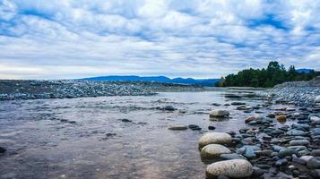 paisaje con un río y una orilla rocosa. foto