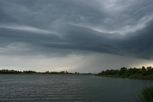 Dramatic landscape with storm clouds over the lake photo