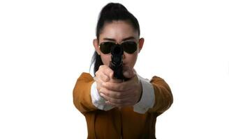 Portrait beautiful Asia woman wearing a yellow suit one hand holding pistol gun at the black background photo