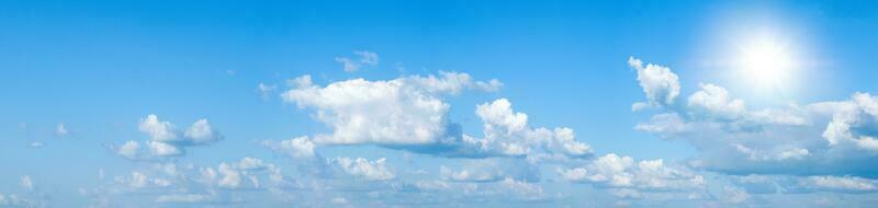 Beautiful clear blue sky with white clouds and sun photo