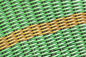 Green plastic woven background with a yellow diagonal line photo