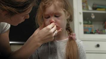 Mom provides first aid to a child with a bloody nose