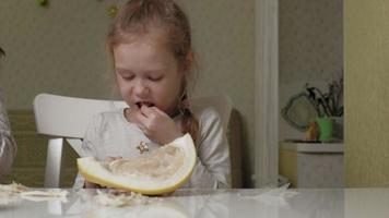 uma garotinha comendo frutas com alças