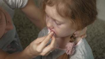 mãe dá primeiros socorros a uma criança com o nariz sangrando video