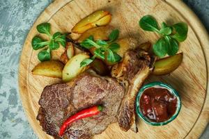 Bone loin with potatoes and basil red sauce photo
