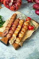 Plates of meat with barbecue and kebab on gray background