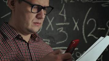 hombre trabajando en un problema de matemáticas con el teléfono video