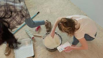 Two Women Mixing Paint in a Bucket video