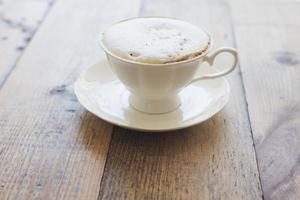Hot cappuccino on wood background photo