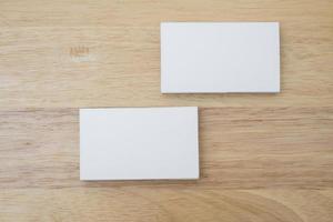 Blank business cards stack up on wooden background photo