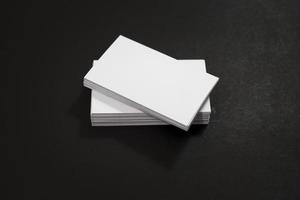Blank business cards stack up on black background photo