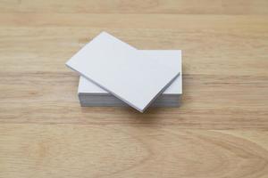 Blank business cards stack up on wooden background photo