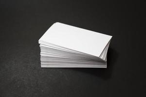 Blank business cards stack up on black background photo