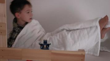 A little boy in checkered pajamas in bed wakes up from a nightmare video
