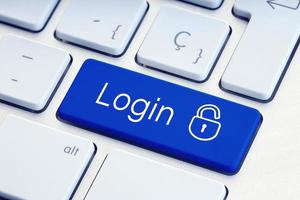Login Word and lockpad on blue computer Keyboard Key Technology security or hacking concept photo