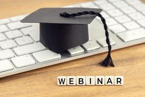 Webinar concept Graduation cap on computer keyboard photo