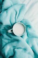 una taza de leche sobre una manta acogedora foto