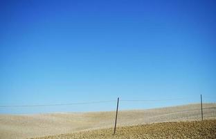 campo marrón bajo un cielo azul durante el día foto