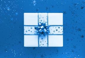 caja de regalo y estrellas sobre un fondo azul monocromo laicos plana foto