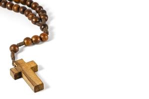 wood rosary with cross at left border and blank area at right side  white background photo