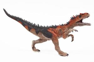Juguete de goma de dinosaurio saurophaganax aislado en blanco foto