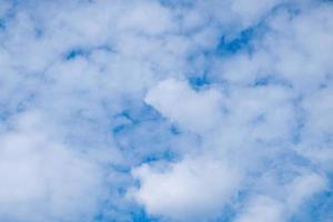 Delicate porous white clouds against blue sky photo