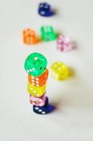 A vibrant colorful macro with depth of field about glass gambling dice isolated and stacked ones on white background photo