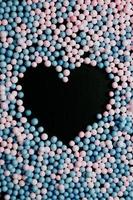 un corazón negro en medio de globos rosas y azules
