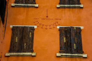 sundial on orange wall photo