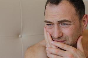 Man staying in bed with toothache