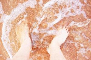 Man feet on the beach wave photo